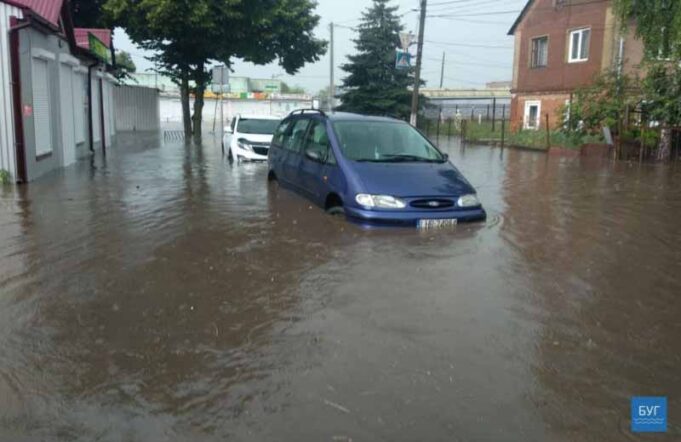 Літня злива у Нововолинську. Затоплена вулиця, будинок та автомобілі Літня злива у Нововолинську. Затоплена вулиця